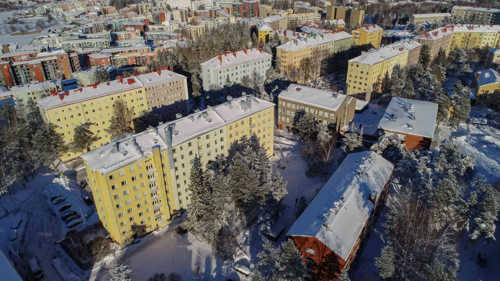 Icopal Katto Oyn Huoltopalvelun kuva joss lumisia kattoja ilmasta kuvattuna